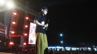 Gus Miftah berceramah di depan ribuan jamaah di pengajian akbar Genteng. Layar LED menampilkan gambar Presiden Jokowi.