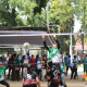 Tim Voli Putri Banyuwangi sedang bermain di lapangan voli. Salah satu pemain sedang melakukan smash, sementara pemain lain bersiap untuk menerima bola.