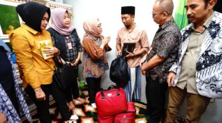 Menteri PPPA Arifah Fauzi sedang berbicara dengan seorang pria di dalam ruangan. Terlihat seorang perempuan terbaring di ranjang rumah sakit.