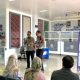 Foto menunjukkan seorang petugas Satpas Polresta Banyuwangi sedang berbicara dengan seorang pria mengenai persyaratan BPJS Kesehatan untuk membuat SIM.