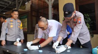 seorang petugas polisi sedang melakukan tes urine mendadak terhadap seorang perwira polisi.