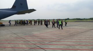 Seorang Dandim sedang menyambut rombongan VIP TNI dan ADF di Bandara Blimbingsari. Terlihat pesawat Hercules milik Royal Australian Air Force di belakang rombongan.