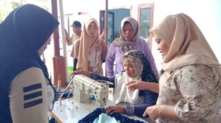 Instruktur pelatihan membimbing peserta menggunakan mesin jahit dalam pelatihan kerajinan kain