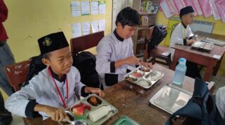 Siswa menikmati makan siang bergizi gratis.