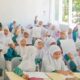 Siswi MI Darunnajah II antusias menulis surat kepada Bupati Banyuwangi dalam kegiatan literasi madrasah.