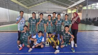Tim futsal SMK Models berpose dengan piala juara.