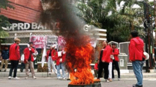Puluhan mahasiswa berdiri membawa poster tuntutan revisi anggaran pendidikan di depan gedung DPRD Banyuwangi.