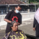 Siswandi sedang mencukur rambut lansia di Graha Lansia Banyuwangi