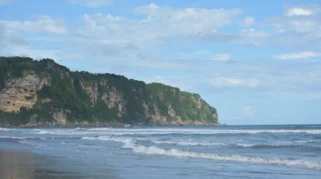 Panorama Pantai Parangtritis dengan pasir hitam dan ombak besar.
