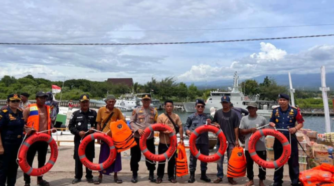 Petugas membagikan life jacket kepada awak kapal rakyat di Pelabuhan Boom Banyuwangi