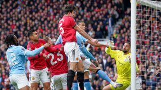 Harry Maguire menanduk bola di laga Manchester United vs Manchester City