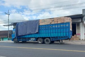 Truk bongkar muat di sepadan jalan nasioanal Rogojampi