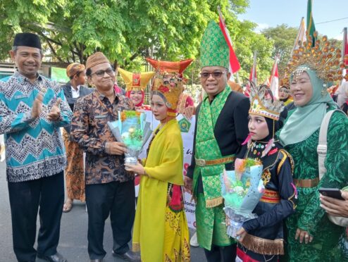 Siswa MIN 1 Banyuwangi mengenakan busana tradisional dalam kirab budaya Hari Sumpah Pemuda. Kepala Kemenag Banyuwangi menerima buket bunga