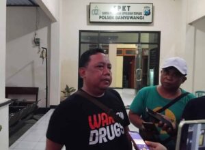 Seorang pria mengenakan kaus "War on Drugs" diwawancarai di Polsek Banyuwangi.