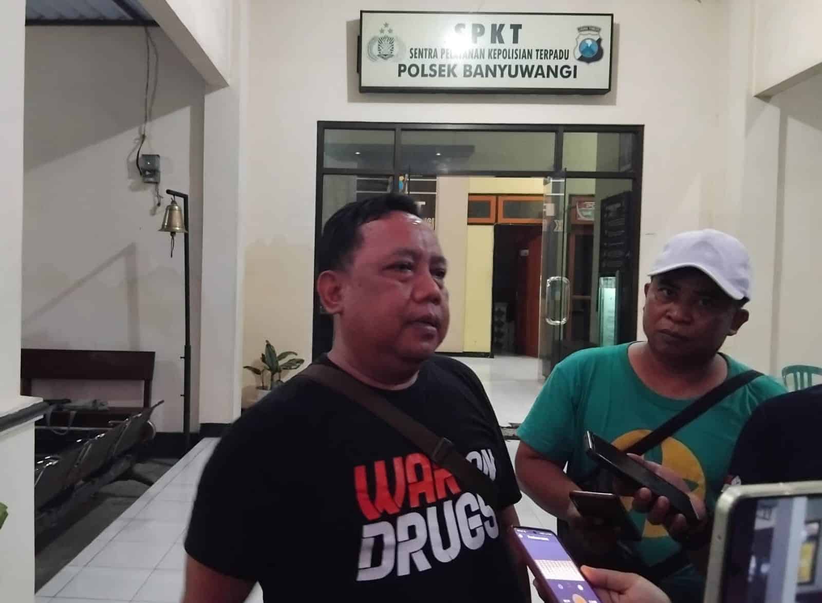 Pasien Rehabilitasi Narkoba Ditemukan Tewas Gantung Diri di Banyuwangi Seorang pria mengenakan kaus "War on Drugs" diwawancarai di Polsek Banyuwangi.