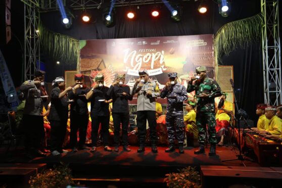 Sejumlah orang sedang menikmati secangkir kopi dalam suasana Festival Ngopi Sepuluh Ewu di Desa Kemiren, Banyuwangi.