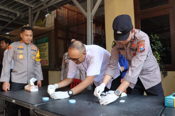 seorang petugas polisi sedang melakukan tes urine mendadak terhadap seorang perwira polisi.