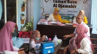 kegiatan posyandu Gelatik Gambiran yang diadakan di Taman Baca Masyarakat Al Djawahir. Terlihat petugas kesehatan dan warga masyarakat yang sedang mengikuti kegiatan tersebut.