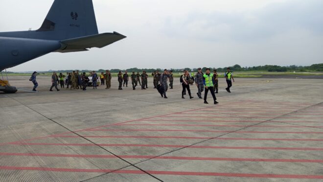 Seorang Dandim sedang menyambut rombongan VIP TNI dan ADF di Bandara Blimbingsari. Terlihat pesawat Hercules milik Royal Australian Air Force di belakang rombongan.