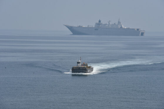 Sebuah kapal perang sedang berlayar di laut. Terlihat kapal perang lain di kejauhan.