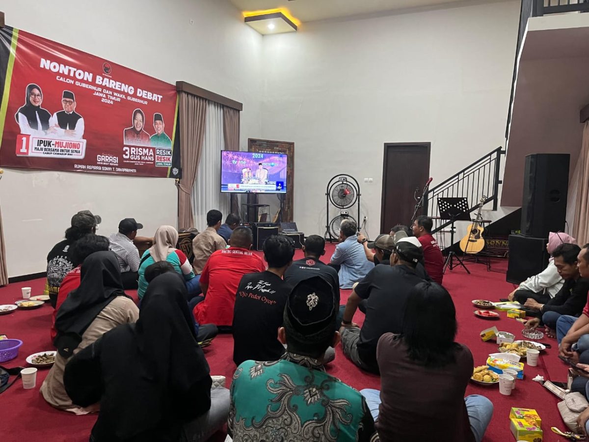 Relawan GARASI Banyuwangi Gelar Nobar Debat Cagub Jatim, Dukung Penuh Risma-Gus Hans Sejumlah orang sedang menonton televisi di sebuah ruangan. Suasana terlihat ramai dan hangat.