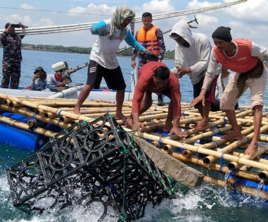Penenggelaman Modul Rumah Ikan di Pantai Gelondong, Banyuwangi Foto memperlihatkan modul rumah ikan yang sedang ditenggelamkan di laut. Terlihat beberapa orang sedang berada di atas kapal.