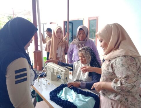 Instruktur pelatihan membimbing peserta menggunakan mesin jahit dalam pelatihan kerajinan kain