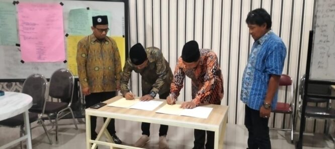 Direktur Utama PT Syarikat Cahaya Media dan Kepala SMK Models berjabat tangan setelah penandatanganan MoU.