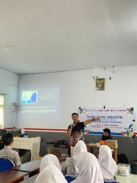 Foto menunjukkan seorang instruktur sedang menjelaskan materi fiber optik di depan para siswa di SMK Models.