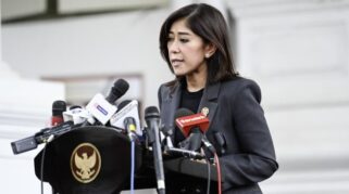 Foto menunjukkan Menteri Kominfo Meutya Hafid sedang berbicara di depan mikrofon saat memberikan keterangan pers.