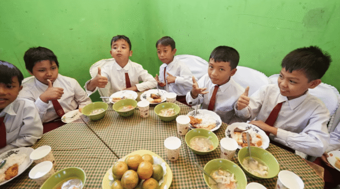 Sejumlah siswa sekolah dasar di Banyuwangi sedang menikmati makan siang bersama dengan senyum ceria.