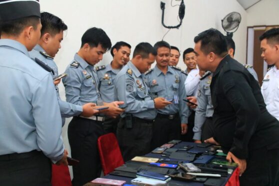 Petugas Lapas memeriksa ponsel pegawai.