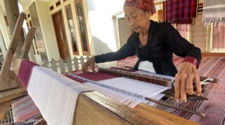 Siyami sedang menenun kain tenun Osing.