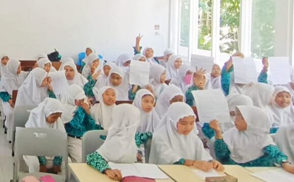 Siswi MI Darunnajah II antusias menulis surat kepada Bupati Banyuwangi dalam kegiatan literasi madrasah.