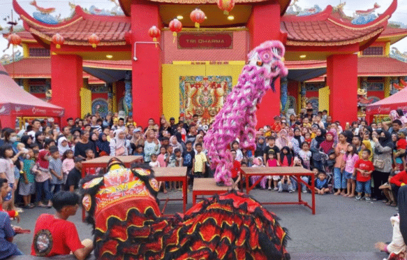 Dua barongsai merah dan pink tampil atraktif di depan kerumunan penonton di Kelenteng Hoo Tong Bio Banyuwangi.