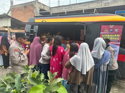 polisi sedang membagikan sayur kepada warga dalam program "Mayur Kamtibmas".