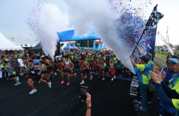Rombongan pelari memulai start East Java Running Festival di Banyuwangi, diiringi confetti dan asap.