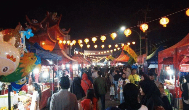 Pengunjung menikmati kuliner dan pertunjukan barongsai di Festival Kuliner Pecinan Banyuwangi.