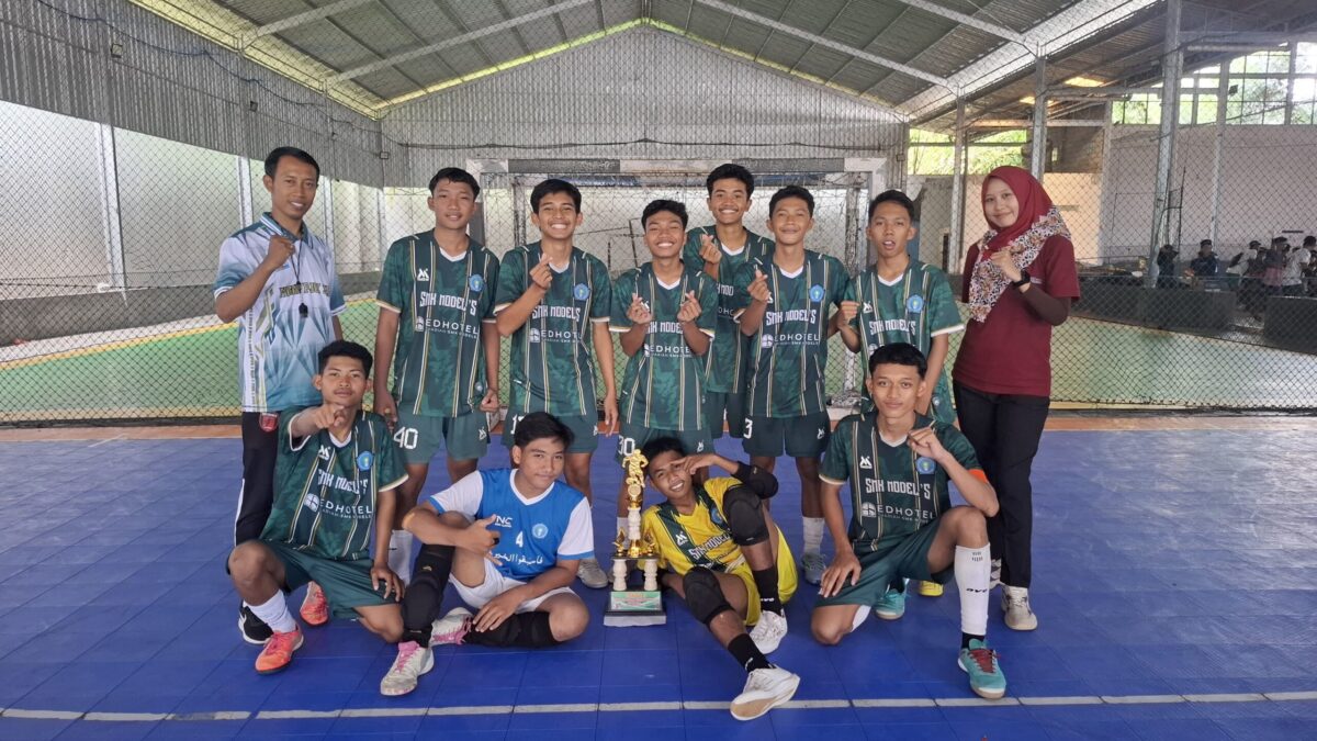 SMK Models Juarai Turnamen Futsal Korwil 6 Banyuwangi Tim futsal SMK Models berpose dengan piala juara.