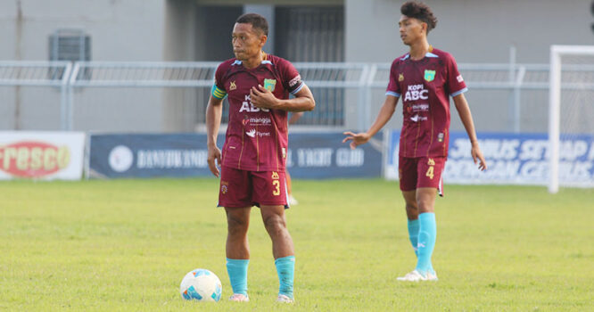 Dua pemain Persewangi Banyuwangi sedang di lapangan sepak bola.