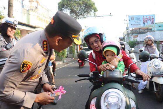 Pengendara menerima cokelat dan helm dari Polresta Banyuwangi di Hari Valentine.