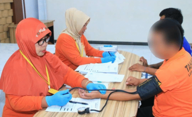 Petugas kesehatan mengambil sampel darah warga binaan selama tes HIV