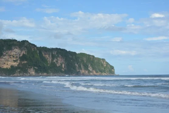 Panorama Pantai Parangtritis dengan pasir hitam dan ombak besar.