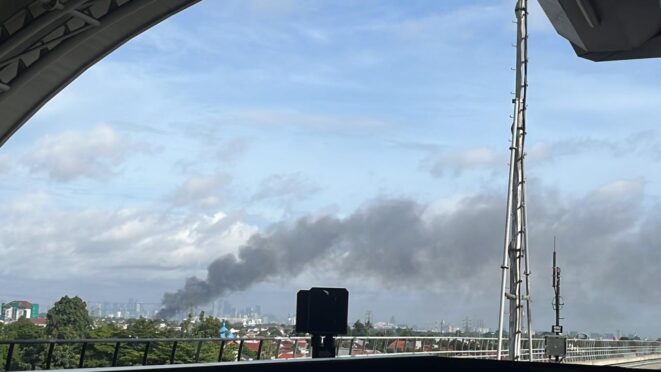 Petugas memadamkan kebakaran di Pasar Induk Kramat Jati