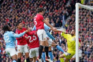 Harry Maguire menanduk bola di laga Manchester United vs Manchester City