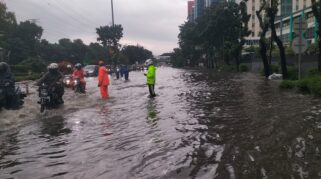 Petugas kepolisian membantu evakuasi warga saat banjir Jakarta