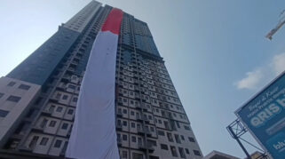Damkar Depok Bentangkan Bendera Merah Putih Raksasa 120 Meter di Lantai 37 Apartemen Envesio